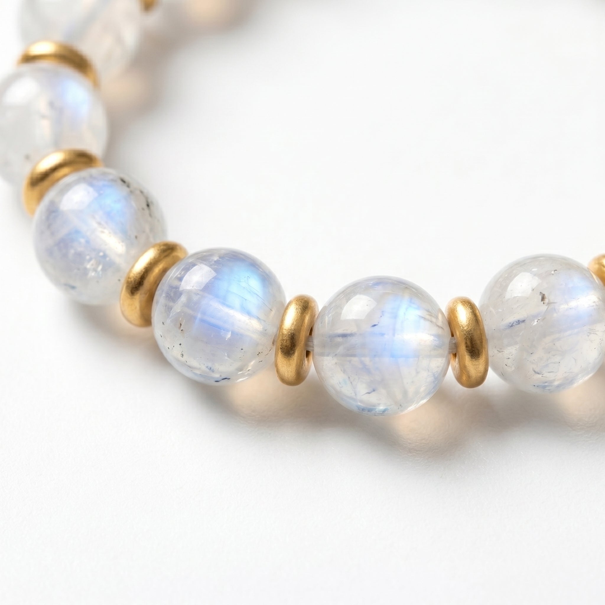 Blue moonstone rounds close-up · white base with shifting blue moon-glow